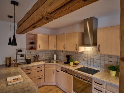 Viel Platz zum Kochen und Verweilen, z.B. bei einem guten Glas Wein an der Theke. Die Wohnküche in der großen Ferienwohnung ist der Mittelpunkt des Raumes.