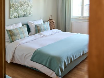 Das Schlafzimmer der großen Ferienwohnung Lindenblick liegt direkt zwischen dem Bad und dem Kinderzimmer und ist über den großen Hausgang zugänglich