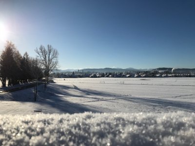 Vom Isny Oval aus, zeigt sich das winterliche Isny mit den Bergen im Hintergrund.