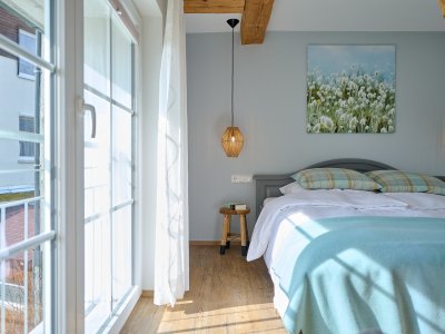 Mit einer idyllischen Aussicht und der Abendsonne im Zimmer, lädt das Schlafzimmer der Ferienwohnung HofBlick 2 im Ferienhof Halder auch tagsüber zum Verweilen ein.