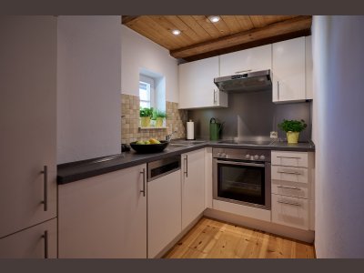 Die Küchenzeile der Maisonette-Wohnung ist komplett eingerichtet und hat ein kleines Fenster.