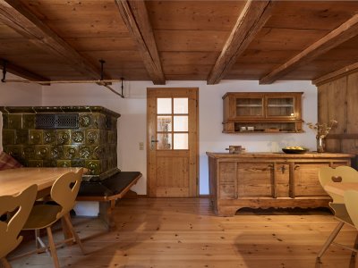Gemütlich und einladend im Erdgeschoss der Sennerei liegt der Aufenthalts-/Gruppenraum für alle Gäste, mit kleiner Küche, Kachelofen, Fernseher und gemütlichen Sitzgelegenheiten.