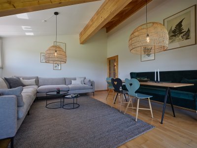 Das großzügige Wohnzimmer der Ferienwohnung WiesenBlick hat eine große, gemütliche Essecke mit Sitzsofa sowie eine große Couchecke.