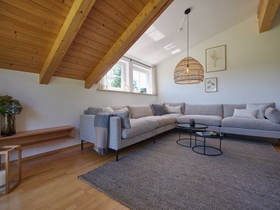 Auf dem großen Sofa der Ferienwohnung WiesenBlick können mehrere Personen relaxen, fernsehen oder lesen.