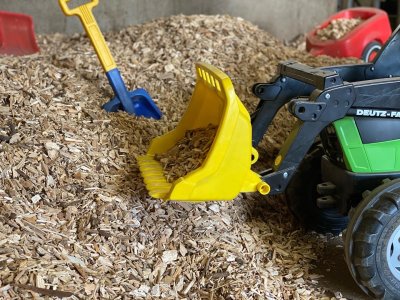 Perfekt für die kleinsten Gäste und bei schlechtem Wetter ist der große Hackschnitzel-Spielplatz mit Schaufeln, Schubkarren, Trettraktoren und viel Platz.