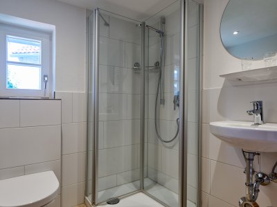 Das neue Badezimmer in der Maisonette I hat ein Fenster, Dusche, WC, Waschbecken und Heizung.