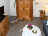 Alpennest gemütlicher Wohnraum mit antikem Bauernschrank und großem Fernseher
