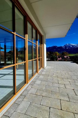 Auf der Terrasse eines modernen Hauses bietet sich ein herrlicher Blick auf die Alpen und den blauen Himmel.