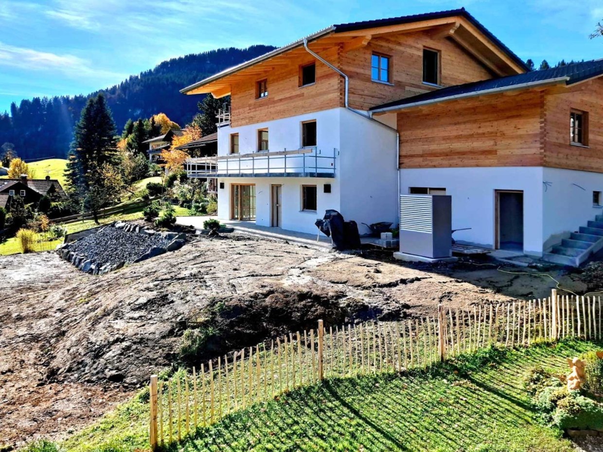 Das Haus wird gerade gebaut und liegt in einer schönen Berglandschaft mit Blick auf die sanften Hügel und Wälder.