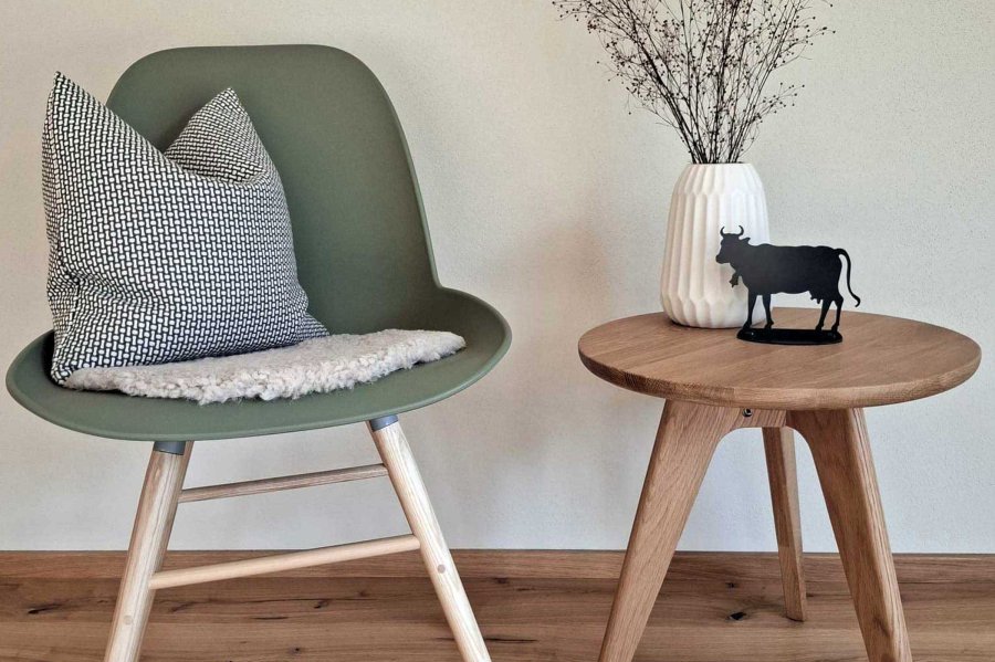 Stuhl mit Kissen und Tisch in einem Raum