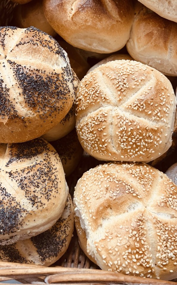 Brötchen in einem Korb auf einem Markt Bunte Brötchen liegen in einem Korb auf einem Markt. Einige sind mit Mohn und andere mit Sesam bestreut.