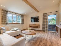 Helles Wohnzimmer mit bequemer Couch und Zugang zum Balkon