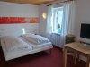 Helles Zimmer mit Doppelbett und Schreibtisch