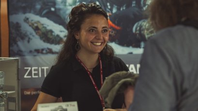 Eine Verkäuferin erklärt die Kameratechnik an einem Stand. Es gibt ein großes Sony-Plakat im Hintergrund.