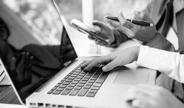 Side-view-businesswoman-s-hands-using-laptop-computer-placed-messy-office-desktop-teamwork-with-business-people-analysis-cost-gr