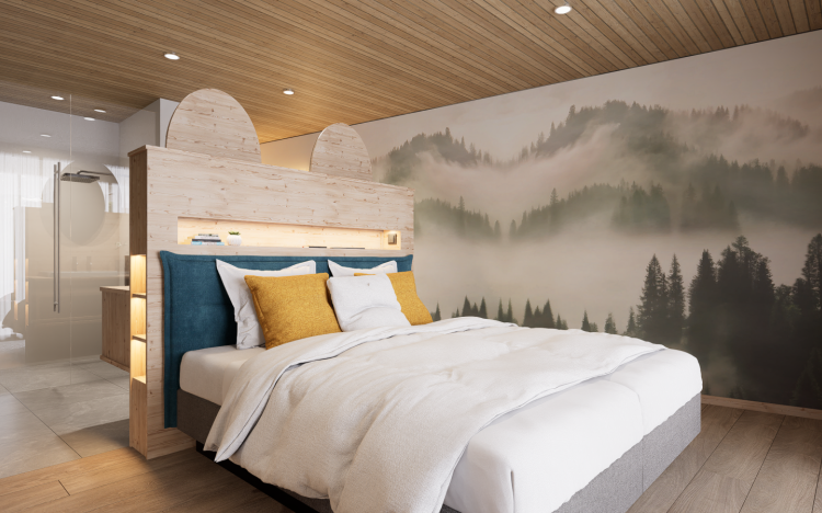 Im Zimmer steht ein großes Bett. An der Wand sieht man eine Berglandschaft mit Nebel. Es ist hell und modern.
