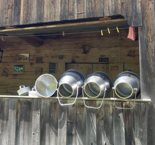 Durch ein Fenster sieht man mehrere Eimer und eine Lampe. Es ist ein schönes Wetter im Freien.