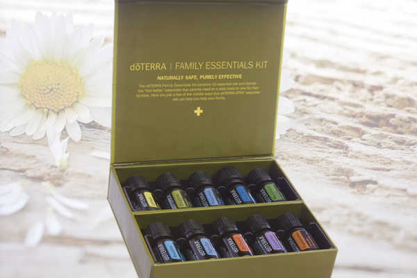 Öle in einer Kiste für Therapien und Gesundheit Es sind Fläschchen mit verschiedenen Ölen in einer Kiste auf einem hellen Untergrund zu sehen.