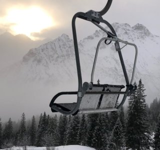 Sessellift vor verschneiten Bergen am Fellhorn, Oberstdorf
