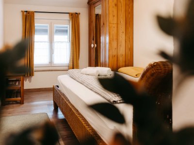 Schön eingerichtetes Schlafzimmer mit Holzdetails und Fenstern, die den Raum erhellen. Einladende Atmosphäre für Erholung.