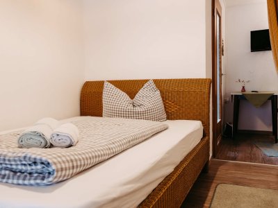 Helles Zimmer mit einem gemütlichen Bett und einem Schreibtisch. Ideal für Ruhe oder produktives Arbeiten am Nachmittag.