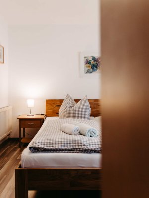 Ein einladendes Schlafzimmer mit einem gemütlichen Bett, angenehmer Beleuchtung und stilvollen Deko-Elementen.