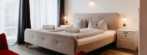 Modernes Schlafzimmer mit zwei Betten und Fensterfront Helles Schlafzimmer mit großem Fenster, zwei Betten und gemütlicher Atmosphäre für entspannte Nächte.