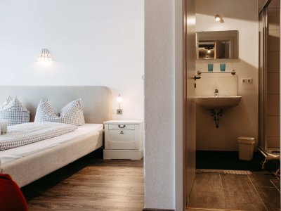 Gemütliches Schlafzimmer mit einem Bad, neutralen Farben und natürlichem Licht zur Entspannung und Erholung.