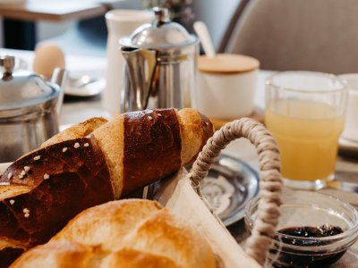 Ein köstliches Frühstück mit Brötchen, Marmelade und Saft auf einem Tisch in einem gemütlichen Café.