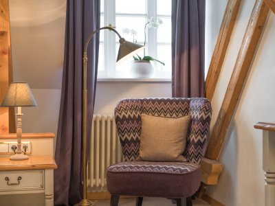 Farblich abgestimmte & edle Stoffe kombiniert mit Holz machen diese Zimmer zu etwas Besonderem