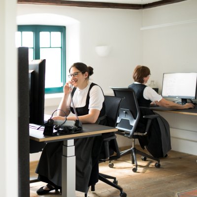 Zwei Mitarbeiterinnen arbeiten an PCs und kümmern sich um die Reservierungen in Haubers Naturresort.