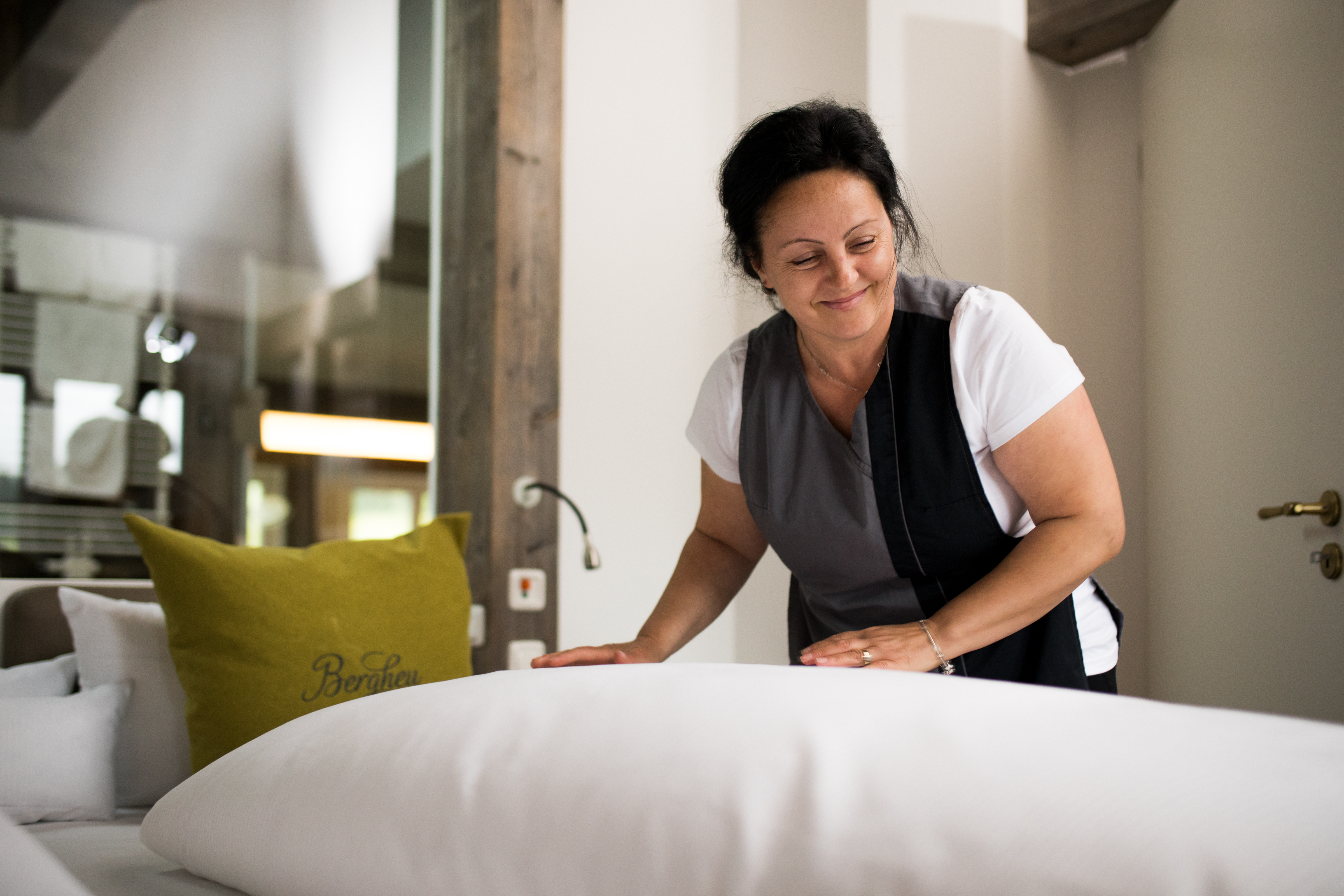 Haubers Mitarbeiterin streicht die Bettwäsche in einem exklusiven Themenzimmer des 4-Sterne-Superior-Hotels glatt.