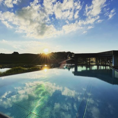 Der Hotel-Pool liegt ruhig in der Abendsonne, bevor sie hinter den Allgäuer Bergen verschwindet.