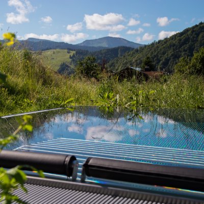 Vor Haubers Wellnesshotel liegt der beheizte Relaxpool mit Blick auf die Allgäuer Bergwelt.