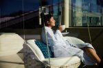 Eine Gästin entspannt im Wellnesshotel Allgäu auf der Sonnenterrasse.