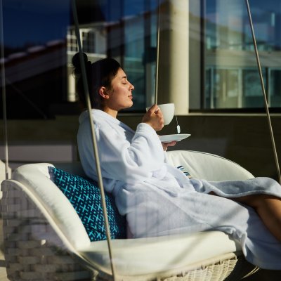 Eine Gästin entspannt im Wellnesshotel Allgäu auf der Sonnenterrasse.