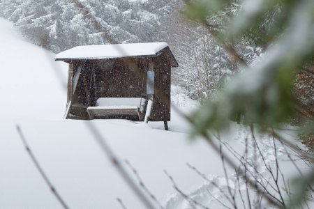 Die Schaukelbank am Haubers Klimapfad liegt im Winter schneebedeckt am Hang der Meerau.