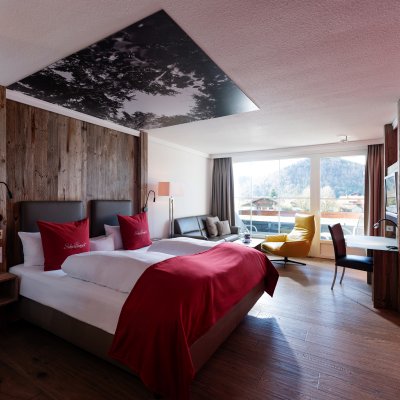 Das Themenzimmer Schwalbennest ist mit einem gemütlichen Doppelbett ausgestattet und in edlen Rottönen gestaltet.
