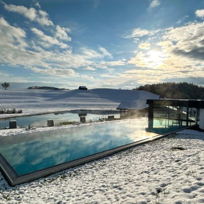 Um den Außenpool des 4-Sterne-Hotels im Allgäu, Haubers Naturresort, liegt der erste Schnee.