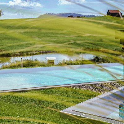 Das Hotel in den Allgäuer Alpen besitzt verschiedene Pools und einen Natursee mit Direktzugang zum Wellnessbereich.