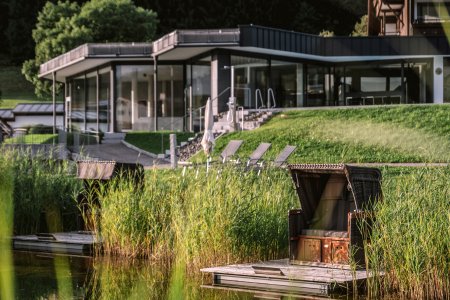 Der Wellnessbereich von Haubers Naturresort liegt direkt am Natursee mit Strandkorb und neben den Außenpools des Hotels.