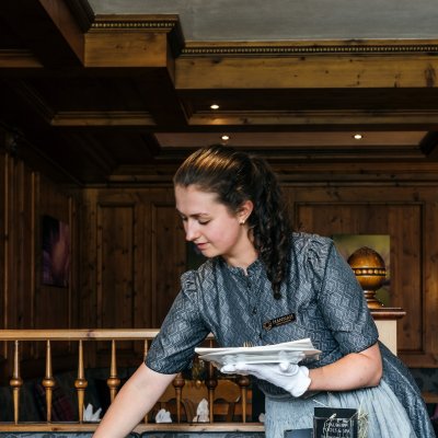 Im Restaurant deckt eine Mitarbeiterin einen schönen Tisch für Gäste ein