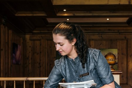 Im Restaurant deckt eine Mitarbeiterin einen schönen Tisch für Gäste ein