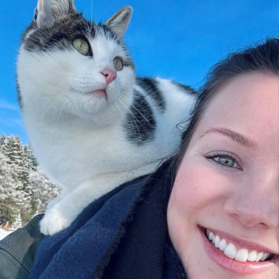 Eine Katze sitzt auf Janina Picards Schulter, die gerade Haubers Klimapfad hinaufgestiegen ist.