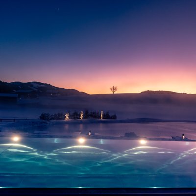 Rund um den Natursee und um den Sportpool des Allgäuer Luxushotels leuchtet Lichtschmuck.