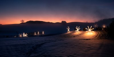 Die Leuchtsterne von Haubers Naturresort tauchen die Schneelandschaft um das Hotel in weihnachtliches Licht.