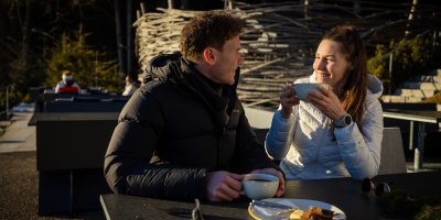 Ein Paar macht an Haubers Schwalbennest Rast, bevor sie zum Wellnesshotel nach Oberstaufen zurückwandern.