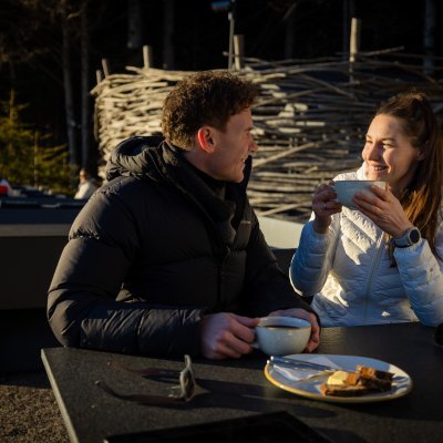 Ein Paar macht an Haubers Schwalbennest Rast, bevor sie zum Wellnesshotel nach Oberstaufen zurückwandern.