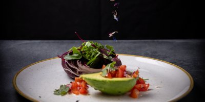 In einer halben Avocado richtet das Basenfasten-Hotel Tomatensalat mit Chicorré und frischen Kräutern an.