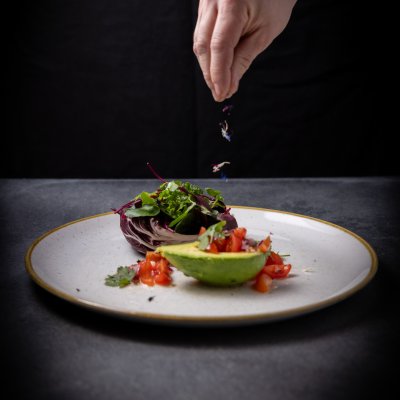 In einer halben Avocado richtet das Basenfasten-Hotel Tomatensalat mit Chicorré und frischen Kräutern an.